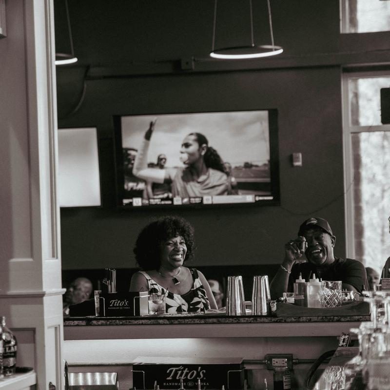 Two guests laughing at the bar at Tisdale's Cigar Lounge